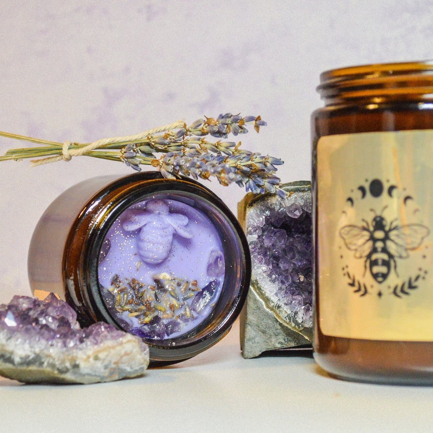 Two brown glass candle jars with sprig of lavender flower